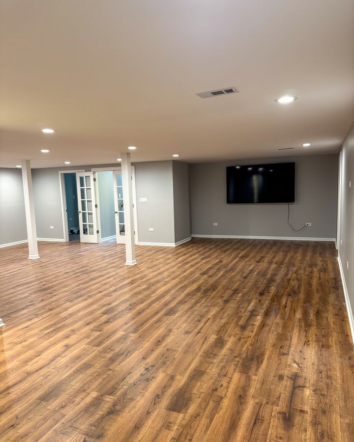 Finished basement with wood-look floors and recessed lights