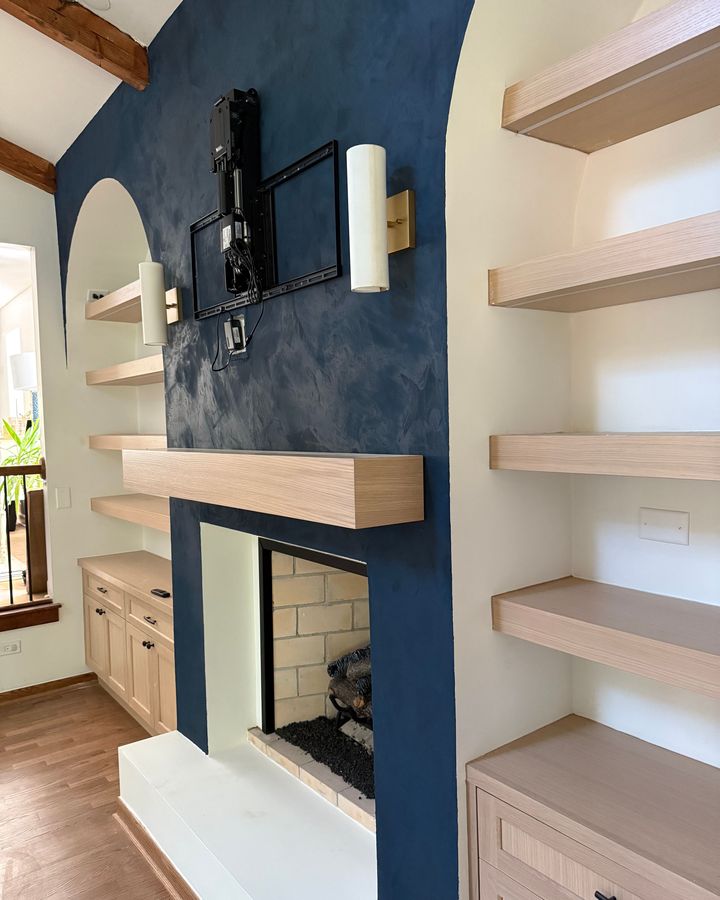 Fireplace wall with navy plaster, oak mantel and built-in floating shelves