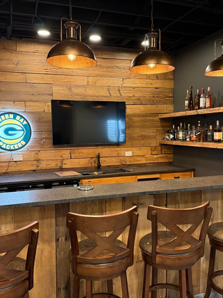 Bar with reclaimed wood wall, pendant lights and leathered granite counter