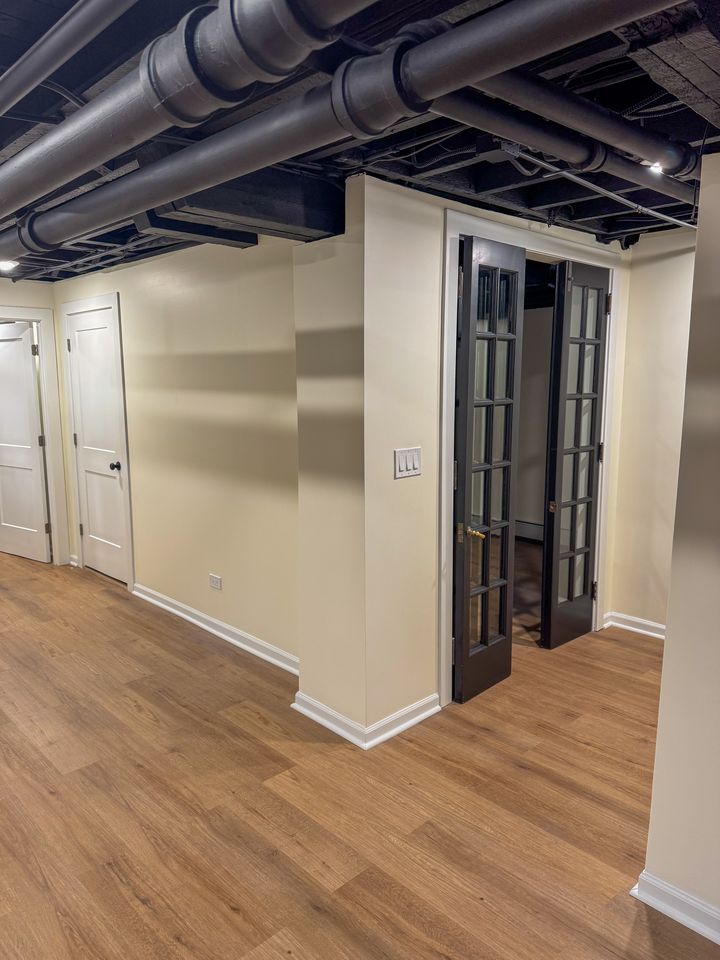 Finished basement hallway with painted exposed ceiling
